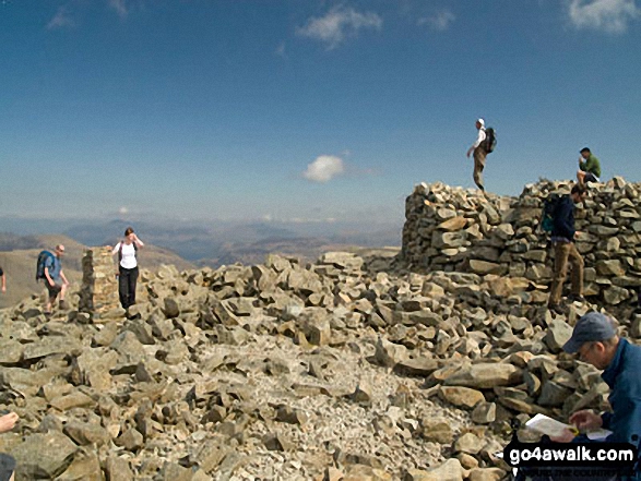 Walk c215 Scafell Pike from Seathwaite (Borrowdale) - Holding on to the Trig point on Scafell Pike summit