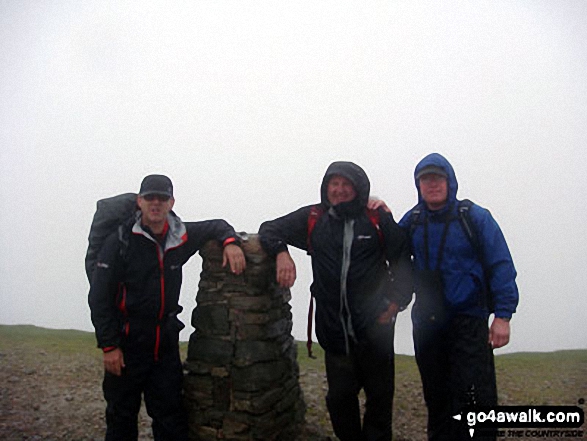 Walk c427 Helvellyn via Striding Edge from Patterdale - Mike, Tim and Shaun at the summit trig point on a very wet Helvellyn - I swear there were seals on the summit!