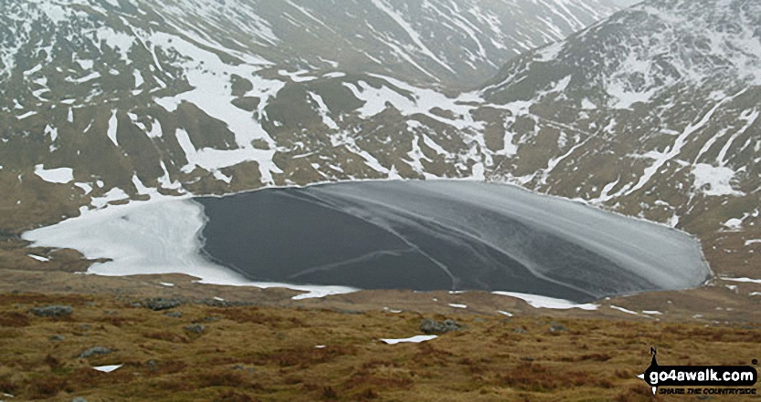 A frozen Grisedale Tarn from the lower slopes of Dollywaggon Pike in the snow