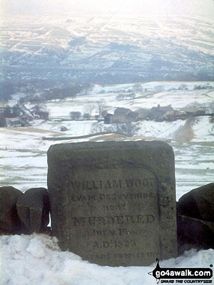 The 'Murder Stone' near Disley - with a snowy New Mills in the background