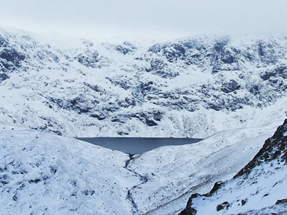 Blea Water with mist shrouding High Street beyond from Dudderwick in the snow