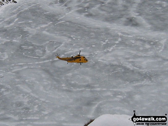 Walk c427 Helvellyn via Striding Edge from Patterdale - Rescue Helicopter above a frozen Red Tarn from Striding Edge