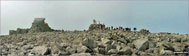 My daughter and friend, climbing up the summit cairn at the top of Ben Nevis